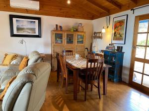 - un salon avec une table, des chaises et un canapé dans l'établissement Sheoak Lodge, à Penneshaw