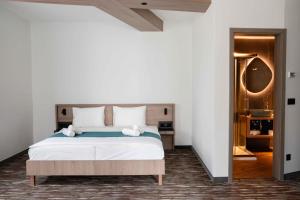 a bedroom with a large bed with white sheets at Avarka in Matrafured