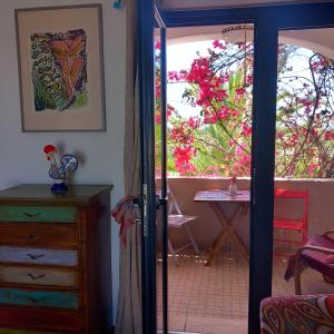 une porte ouverte menant à une chambre avec une table et des fleurs dans l'établissement BO-Piscine chauffée, Bénagil-Carvoeiro, à Carvoeiro