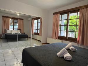 a bedroom with a bed and a mirror with towels at Pegasus House in Kórinthos