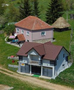 uma casa com um telhado vermelho numa colina em Odmorište Vrelo Vape em Sjenica