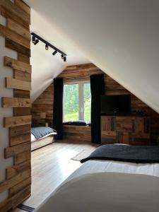 a attic bedroom with a bed and a window at Rajskie wzgórze słoikowo 
