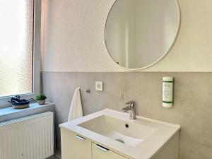 ein Badezimmer mit einem weißen Waschbecken und einem Spiegel in der Unterkunft City Hotel Hameln in Hameln + 36 Fotos