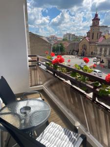 a balcony with a table and a view of a city at Sunny apartment in Vršac