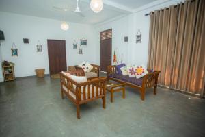 a living room with two chairs and a couch at koggala House By The Rock in Habaraduwa