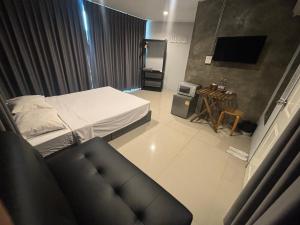 a small bedroom with a bed and a couch at Udomsuk Inn & Cafe Since 2019 - BTS Udomsuk in Bangkok