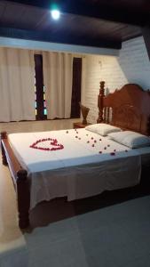 a bedroom with a bed with red flowers on it at Pousada Lua Vermelha in Caponga