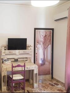 a room with a desk with a tv and a tree at B&B CARRUBBELLE in Ragusa