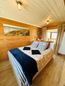 um quarto com uma cama num quarto de madeira em La Villa plein vent "La Cabine" vue mer em Barneville-Carteret