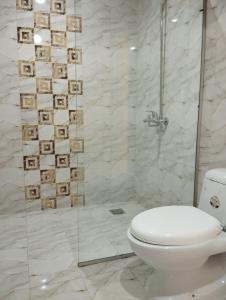 a bathroom with a toilet and a glass shower at Hotel H6 in Rawalpindi