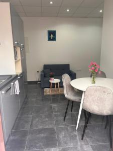 a living room with a table and chairs and a couch at Apartman Daisy in Slatine +3 photos