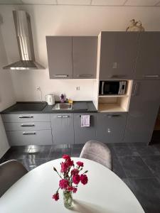a kitchen with a table with a vase of flowers on it at Apartman Daisy in Slatine