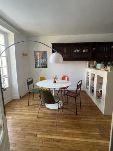 ein Esszimmer mit einem Tisch und Stühlen in der Unterkunft Quai Sisley in Villeneuve-la-Garenne
