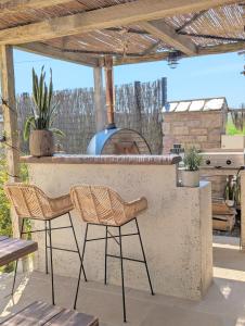 a patio with two chairs and an outdoor grill at Villa vue Mer -5 mn des plages - grand jardin-cuisine d'été- 4 chambres in Planguenoual