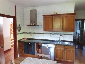 a kitchen with wooden cabinets and a sink and a stove at Casa sobre el mar 10 personas in Mutriku