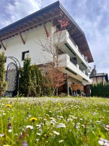 um edifício com um campo de flores à sua frente em Appartementhaus Handl em Leutasch