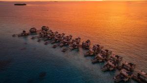 妮蘭朵南環礁的住宿－Angsana Velavaru - All inclusive SELECT with 50 percent off on Return Sea Plane Transfers for Stays of 5 Nights or more on selected rooms，水中一组船只的空中景观