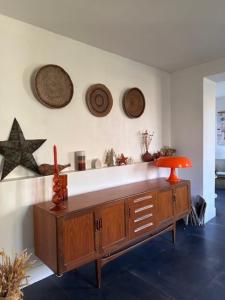ein Wohnzimmer mit einem Tisch und einigen Hüten an der Wand in der Unterkunft Quai Sisley in Villeneuve-la-Garenne