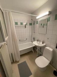 ein Badezimmer mit einer Badewanne, einem WC und einem Waschbecken in der Unterkunft Mysiga Lägenheten I Örebro in Örebro