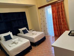 ein Hotelzimmer mit 2 Betten und einem Schreibtisch in der Unterkunft Oskar Hotel in Sarandë