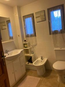 Baño blanco con lavabo y aseo en casa di Rosa, en Patrimonio