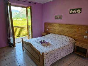 a bedroom with a bed with purple walls and a window at Antico Fienile Agritur in Mezzocorona