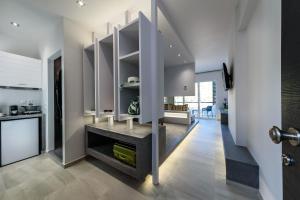 Una cocina con paredes blancas y un pasillo con estantes. en Solar Apartments by Amara Living, en Agia Marina de Nea Kydonia