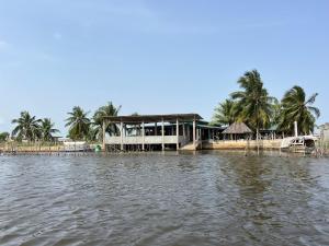 una casa en medio de un cuerpo de agua en Hotel Germain - Ganvié Holiday Resort, en Ganvié