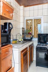 a kitchen with a sink and a stove top oven at EG Studio-Carrefour ISTAMA-Sable Bonamoussadi-0m from Road in Douala