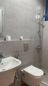 een badkamer met een wit toilet en een wastafel bij ماجيك سويت الفحيحيل Magic Suite ALFahaheel in Koeweit
