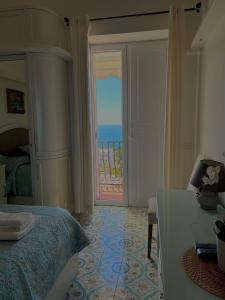 a bedroom with a bed and a door to the ocean at Capri Suite Dreams in Capri