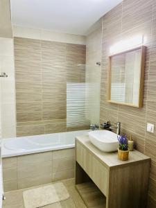 a bathroom with a sink and a bath tub at Home Sweet Home in Braşov