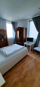um quarto com uma cama, uma secretária e 2 janelas em Hotel Rhein-Residenz em Bad Breisig