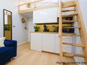 cocina con armarios blancos y cama elevada en BaySide Apartments Center City, en Gdansk