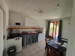a kitchen with white cabinets and a table and a tableablish at Le soleil souriant in Banne