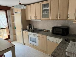 a kitchen with wooden cabinets and a microwave at Unquera (mar y montaña) in Unquera +8 photos