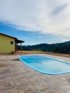 una gran piscina azul en un patio en Pousada Helena e Heloá en Serra Negra