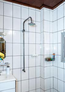 a shower in a bathroom with white tiles at EG Studio-Carrefour ISTAMA-Sable Bonamoussadi-0m from Road in Douala