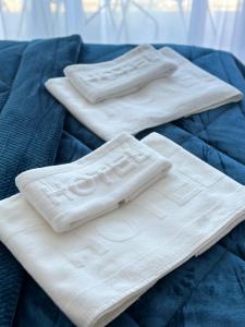 due asciugamani bianchi posti sopra un letto di Villa Milan a Sveti Stefan