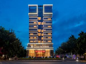 a tall building with an american flag on it at Jinjiang Metropolo Hotel - Shenzhen Longgang Central City Longcheng Plaza in Longgang