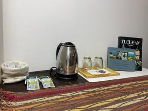 una cafetera sobre una mesa con libros y gafas en GMP suites en San Miguel de Tucumán