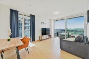 维也纳Luxury Penthouse I Rooftop Pool I Self Check-in的客厅里有一张沙发、一张桌子和一台电视