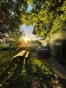 a picnic bench in a park with the sun setting at Silver Airstream Glamping & Rental in Chichester