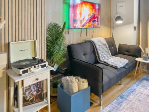 uma sala de estar com um sofá e uma televisão em 3Bed 2Bath with Garden sauna & Hot Tub em Londres
