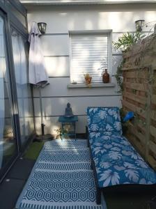 a small porch with a bench and a window at appartement cosy à 200 du tram B chambre séparée Petite véranda lumineuse donnant sur jardinet in Pessac