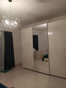 Zimmer mit einem Spiegel und einem Kronleuchter in der Unterkunft 3 bedrooms flat at Attard in Attard
