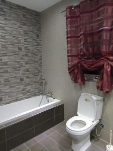 ein Badezimmer mit einem weißen WC und einer Badewanne in der Unterkunft 3 bedrooms flat at Attard in Attard