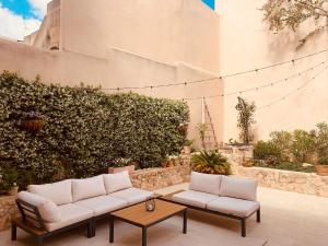 un patio con 2 sofás blancos y una mesa en Atrium Suites Mallorca en Porreres