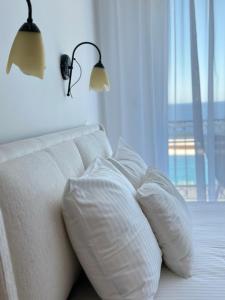 a white bed with two pillows and a window at Villa Milan in Sveti Stefan