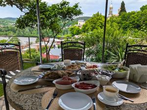 une table avec des assiettes et des bols de nourriture dans l'établissement Veranda Boutique Hotel Kutaisi, à Koutaïssi